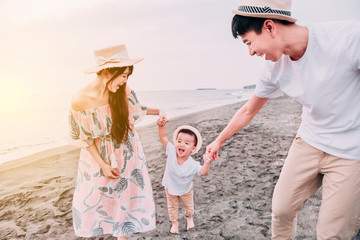 Wall Mural - happy  asian family playing on the beach  at sunset