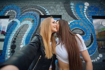 two very cute young girls posing as top models on a street in Europe on vacation,sisters actively posing on a sunny summer day ,very happy and joyful people