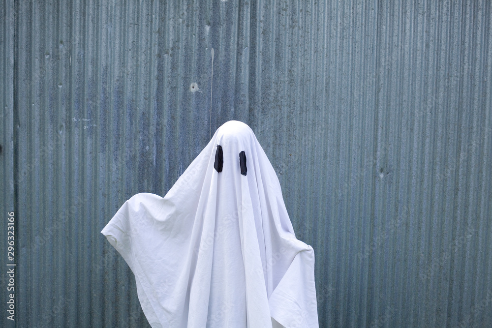 white ghost in front of a garage door - obrazy, fototapety, plakaty 
