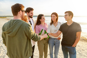 Canvas Print - friendship and leisure concept - group of happy friends toasting non alcoholic drinks on summer beach