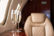 © LIGHTFIELD STUDIOS - selective focus of interior of plane with champagne glasses for trip