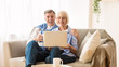 © Prostock-studio - Happy mature couple surfing internet on laptop