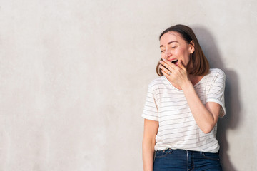 Wall Mural - beautiful middle aged woman laughing with hand over mouth by white wall