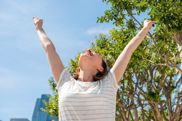 Wall Mural - cheerful older woman with arms raised outside