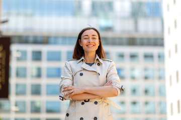 Wall Mural - smiling older woman standing outside with arms crossed