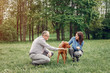 © hetmanstock2 - Couple in a forest. Adult pair with cute dogs. Lady in a blue shirt