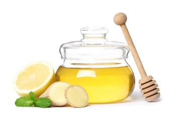 glass jar full of honey and dipper, ginger, lemon and mint isolated on a white background