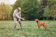 © hetmanstock2 - Hundsome man in a park. Adult male with cute dog
