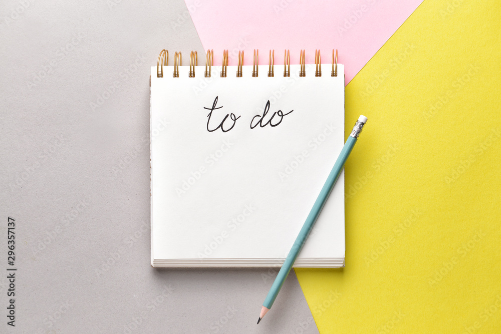 Empty to do list and pencil on color background