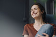 © Kniel Synnatzschke/Westend61 - Portrait of laughing young woman sitting on lounge chair at home