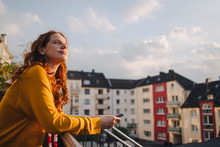 Redheaded Woman Standing On Roof Terrace