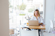 © DREAMSTOCK1982/Westend61 - Portrait of smiling young woman with laptop on table in a cafe