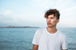 © Rafa CortÈs/Westend61 - Portrait of young man with curly hair by the sea