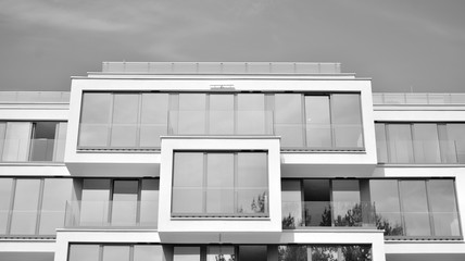 Wall Mural -  Fragment of a facade of a building with windows and balconies. Modern home with many flats. Black and white.