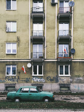 Apartment Building With Graffiti And Green Car