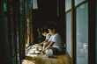© Taishi Arashida - Siblings with watermelon slices sitting on patio