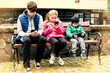 © Мар'ян Філь - Three children of all ages sit on the bench and look at the phones, instead of walking, resting the children playing games on the phone. Addiction to phones, gadgets