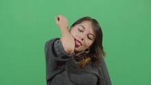 Impossible Moves For Humans Woman Trying To Reach The Elbow With The Tongue. Studio Isolated Shot Against Green Screen Background