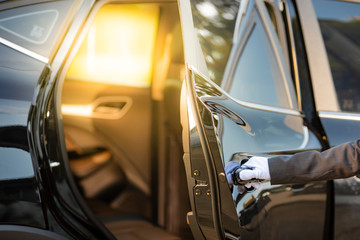 Wall Mural - Closeup of Chauffeur opening car door with glove.