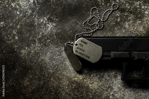 Cuadros en Lienzo Blank military dog tags and a gun on abandoned rusty metal plate