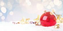 Red Christmas Ball With Golden Stars On Snow With Copy Space