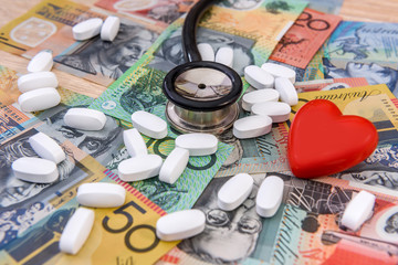 Wall Mural - Stethoscope with red heart and pills on australian dollars