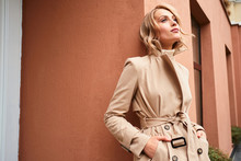 Beautiful Stylish Blond Girl In Trench Coat Dreamily Looking Away Outdoor