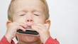 © MEDIAIMAG - Little kid playing music on harmonica with passion