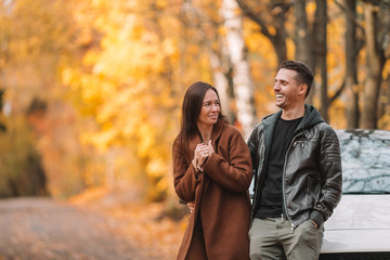 Happy family walking in autumn park on sunny fall day