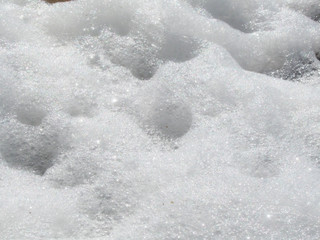 White sea foam close up on the sea coast shiny macro