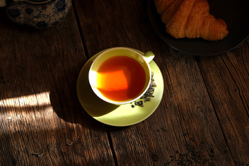 Wall Mural - Tea composition. A Cup of aromatic tea on the background of an old wooden table.