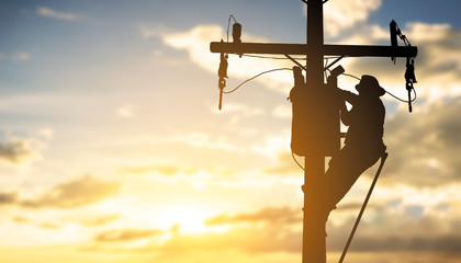 silhouette engineer working maintenance transformer on pole electric