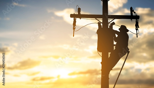 Fotomural silhouette engineer working maintenance transformer on pole electric