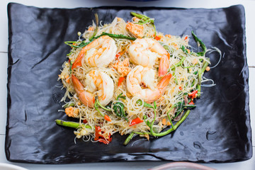 Thai Cuisine, Stir-fried rice vermicelli and water mimosa with prawns on black plate