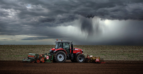 beautiful landscape with a farmer plowing his fields before the storm