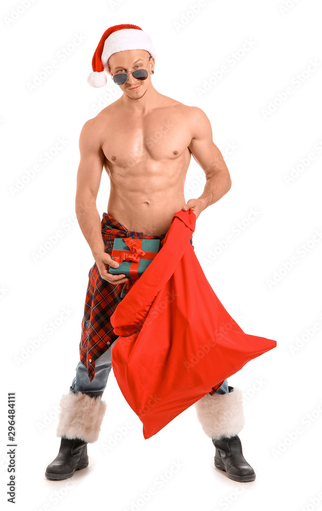 Young athletic Santa Claus with gifts on white background