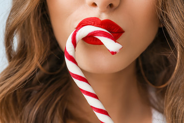 Beautiful woman with candy cane, closeup