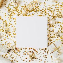 Christmas, New Year Composition. Square Blank Frame With Copy Space, Christmas Baubles, Gift Box, Tinsel, Gold Decoration On White Background. Flat Lay, Top View Festive Holiday Mockup.