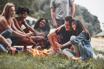 Wall Mural - On vacation. Group of people have picnic on the beach. Friends have fun at weekend time