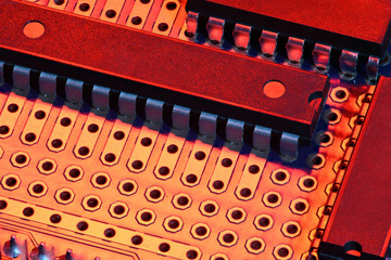 printed circuit board and microchip in red light closeup - electronic component for digital equipment, concept for development of electric computer circuits