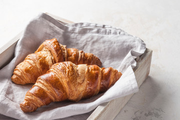 Croissants in a wooden box on a gray background