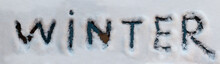 Wintertime Concept. Winter Word Written With Finger On A Snow Melted Of Car Window.