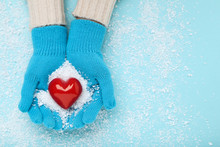 Hands In Knitted Mittens Holding Red Heart On Blue Background