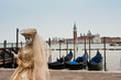 A masked woman for the Venice carnival in San Marco piazza, in the background the island of San Giorgio Maggiore. Italy