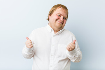 Wall Mural - Young authentic redhead fat man raising both thumbs up, smiling and confident.