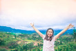 © nattawatstocker - Happy Asian woman stands her arms on a beautiful view of the mountains and the sky