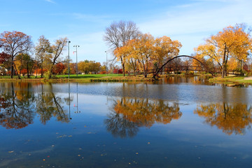 Wall Mural - beautiful fall landscape with a bridge in the city park. scenic view with colored trees and old styl