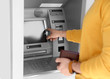 © New Africa - Young man using modern cash machine outdoors, closeup