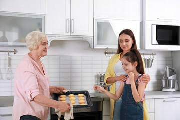 Poster - Happy grandmother helping her family to bake cookies in kitchen