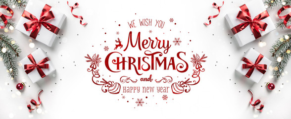 Wall Mural - merry christmas text on white background with gift boxes, ribbons, red decoration, fir branches, bok